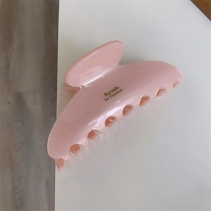 Vue détaillée de la pince à cheveux rose brillante avec texte doré Barrette La France