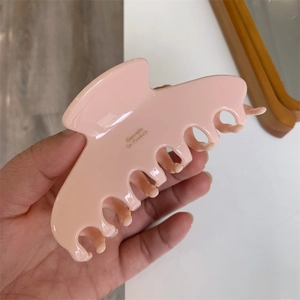 Close-up of pink acetate hair claw with gold Barrette la France lettering detail