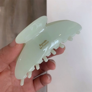 Détail de la pince à cheveux en acétate vert clair avec lettrage doré Barrette la France