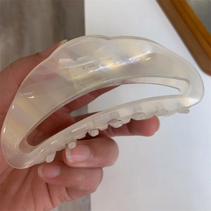 Close-up of crescent acetate hair claw with France Handmade gold lettering detail