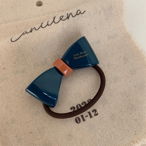Detail of contrast bow hair tie with Amy Bear Handmade inscription on beige fabric