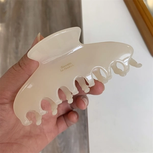 Detailed macro view of cream acetate hair claw clip featuring golden Barrette La France text