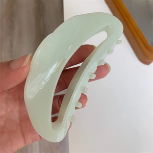 Detailed macro view of the inner handmade lettering on a light green acetate hair claw clip
