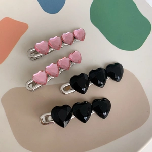Set di quattro fermagli per capelli a cuore con cristalli rosa e neri su basi in argento