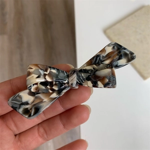 Détail de la pince à cheveux en acétate faite main avec motif marbré et double nœud