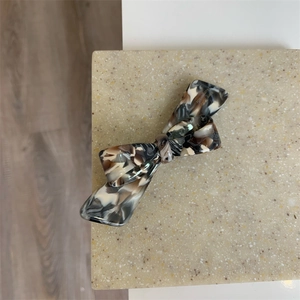 Gros plan détaillé sur la barrette en acétate faite main avec design nœud motif marbre