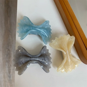Detail of elegant acetate hair clips with wavy edges and small rhinestone accents