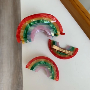 Detail view of colorful rainbow acetate hair claw clips and side bangs duckbill barrettes