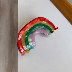 Detailed close-up of rainbow acetate hair clip with vibrant marble textures and layers