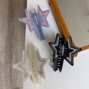 Detail showing acetate star hair claws with shimmering rhinestones in three colors