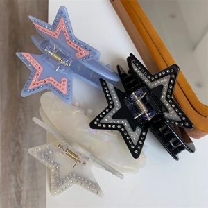 Detail showing acetate star-shaped hair claws with rhinestones in multiple colors