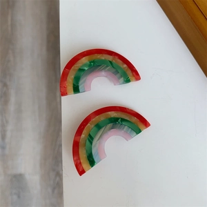 Detail of colorful rainbow acetate hair clips with vibrant five-color layered pattern