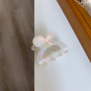 Macro shot of iridescent pearl white rabbit ear hair clip with gold handmade text