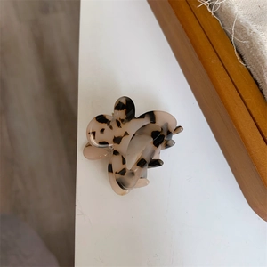 Detail of a butterfly hair claw clip featuring a stylish milk tea leopard tortoiseshell pattern