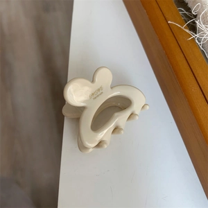 Detail of cream rabbit-ear hair clip with SUNSHINE Handmade gold lettering side view