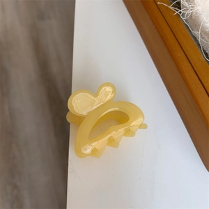 Macro shot of a pale yellow butterfly hair claw clip with a handmade texture