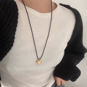 Minimalist adjustable black cord necklace with a polished gold heart-shaped pendant for women