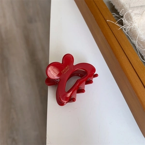 Detailed macro view of red butterfly hair clip featuring golden sunshine handmade text