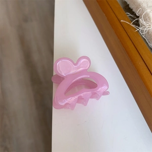 Close-up of pink acrylic hair claw clip featuring golden Sunshine lettering design