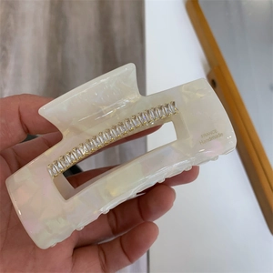 Détail de la pince à cheveux en acétate marbré avec strass et texte France Handmade