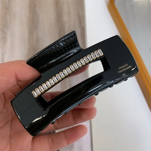 Détail de la pince à cheveux noire avec strass brillants et marquage doré fait main