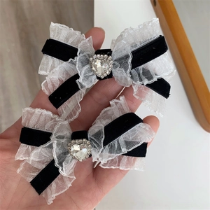 Detail of velvet bow hair clips with white lace ruffles and heart-shaped rhinestones
