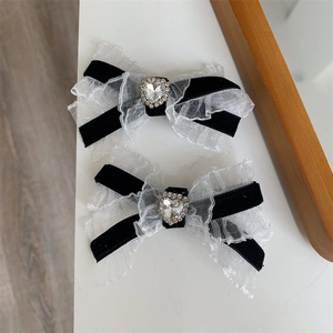 Detail of velvet and lace bows with heart-shaped rhinestones and wavy mesh edges