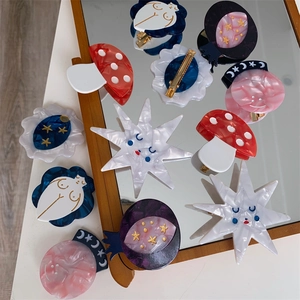 Macro shot of unique handmade acetate hair clips featuring mushroom and star designs