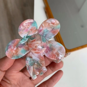 Close-up of pink and green marbled acetate flower hair claw clip with five petals