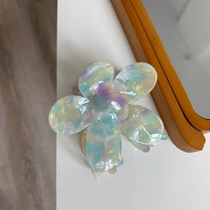 Macro shot of acetic acid flower hair claw with pearl luster and multicolor shell effect