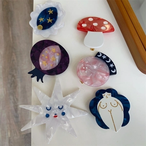 Detail of creative acetate hair clips featuring mushrooms, stars and abstract shapes