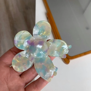 Close-up of a floral acetate hair claw with iridescent marble texture in blue and purple