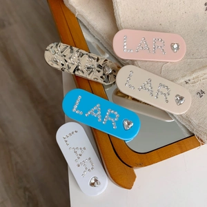 Détail de cinq barrettes colorées en acétate avec des strass LAR et des gemmes en cœur