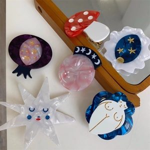 Close-up of creative acetate hair clips with mushroom, star and moon artistic designs