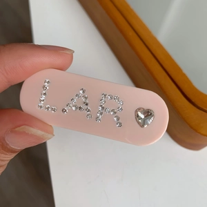 Barrette ovale rose en acétate avec lettres LAR en cristal et décor de strass en cœur