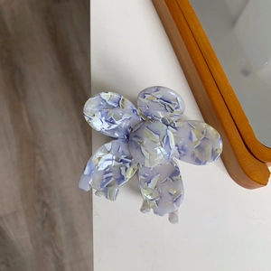 Detail of flower hair claw clip in purple marble acetate with elegant petal design