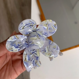 Close-up of marble pattern acetate flower hair claw clip with purple and blue texture