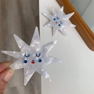 Detailed macro of a star-shaped acetate hair clip featuring a cute smiling face pattern