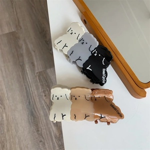 Drei kleine Hunde Design Acetat Haarklammern in verschiedenen Farben auf Holzgrund
