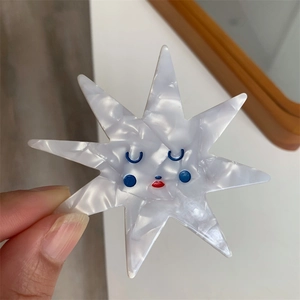 Detail showing an octagonal star-shaped hair clip made of pearlescent marble acetate