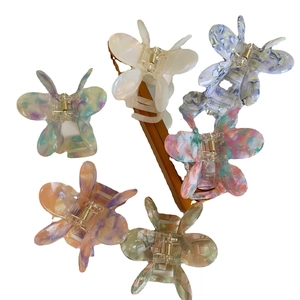 Elegant acetate butterfly hair claws set with marble textures and pearlescent finishes