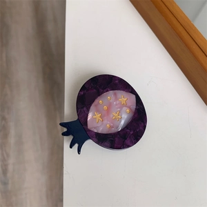 Detailed view of handmade pomegranate hair clip with purple marble acrylic and gold stars