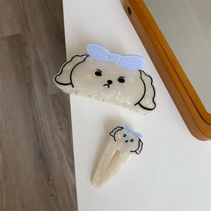 Dettaglio del set con molletta per capelli a forma di cane e clip con fiocchi blu