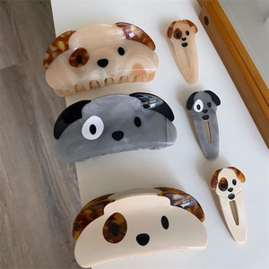 Detail showing various acetate dog-shaped hair claws and clips in neutral marble textures