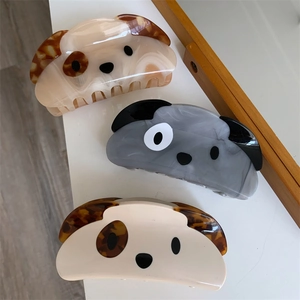 Detailed view of three cute acetate dog hair claws in beige, grey, and cream finishes