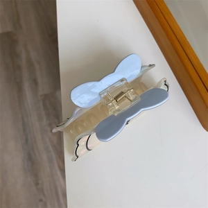 Vista dettagliata della pinza per capelli blu a forma di fiocco con finitura in acetato