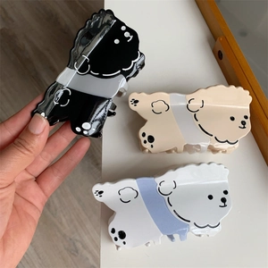 Vista detallada de pinzas de pelo grandes con forma de perro Teddy en acetato