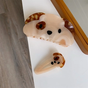Detail view of acetate dog hair clips in large and small sizes with marble texture
