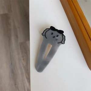 Vista dettagliata della molletta per capelli a forma di cucciolo con fiocco nero chic