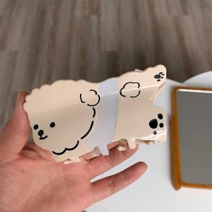 Detalle de la linda pinza para el pelo con forma de perro crema y huellas de patas